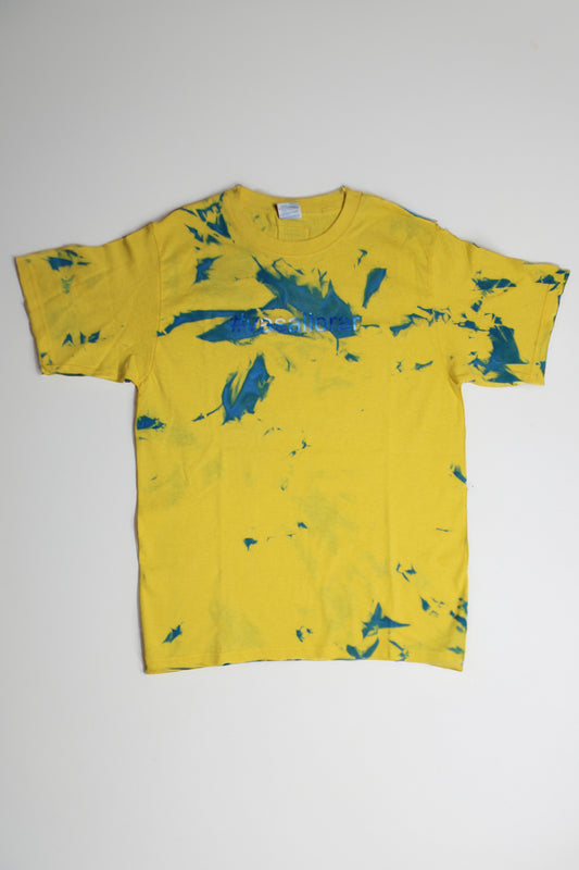 Yellow cotton T-shirt intervened with spray paint that says: “Vas a llorar?”